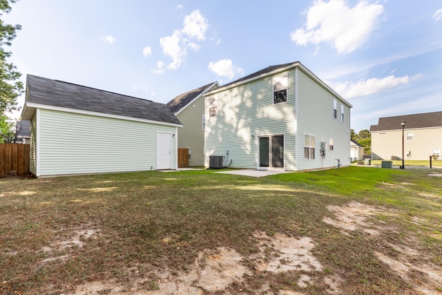 rear view of house with central AC, a patio, and a lawn