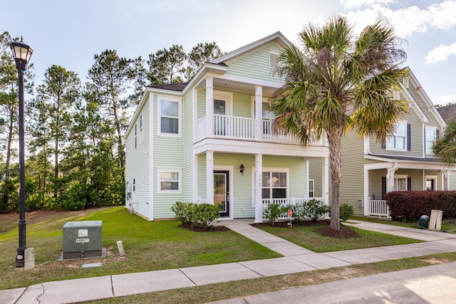 view of front of property with a front lawn, a balcony, and covered porch