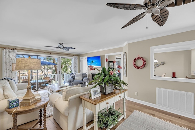 living room with crown molding, light wood-style flooring, visible vents, and a ceiling fan