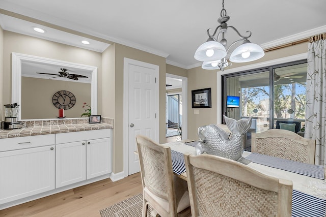 dining space with ceiling fan with notable chandelier, ornamental molding, light wood-style flooring, and recessed lighting