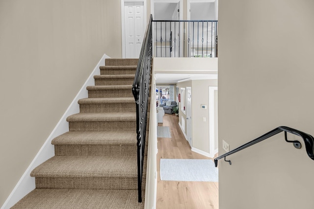 staircase featuring wood finished floors and baseboards