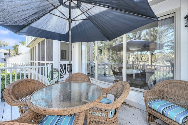 exterior space with a sunroom and outdoor dining area