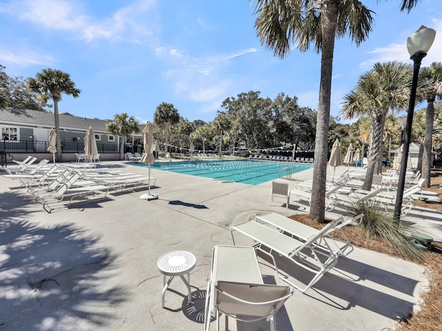 pool with a patio area and fence