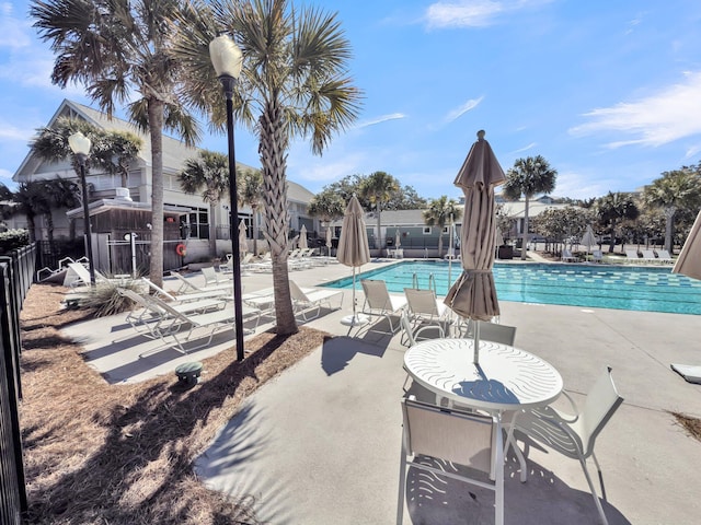 pool with a patio and fence