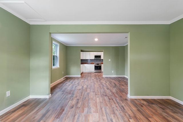 unfurnished living room with ornamental molding and dark hardwood / wood-style floors