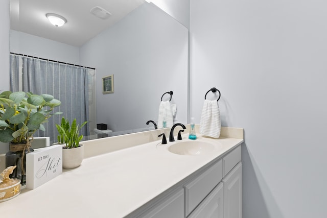 bathroom featuring curtained shower and vanity