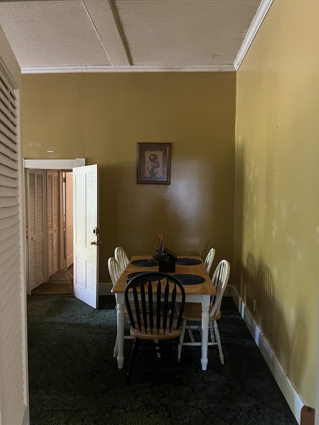 carpeted dining space with ornamental molding and a textured ceiling