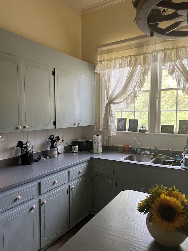 kitchen with gray cabinetry, white cabinetry, ornamental molding, and sink