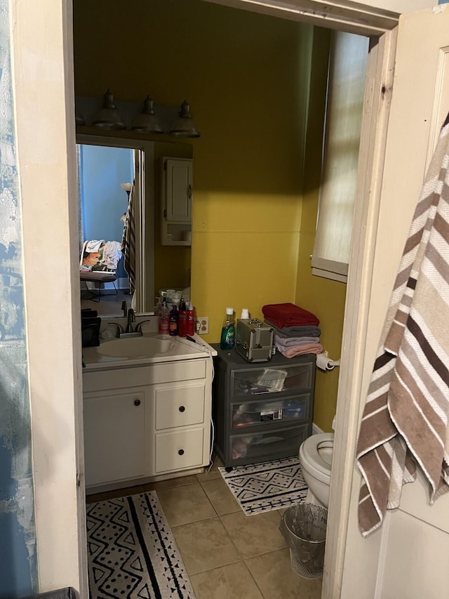 bathroom with tile patterned flooring, vanity, and toilet