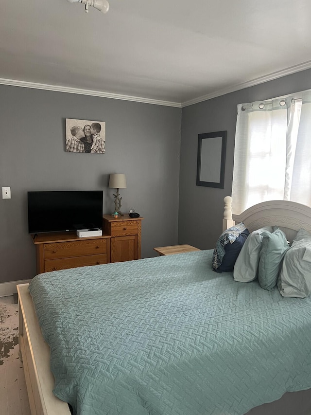 bedroom with wood-type flooring and crown molding