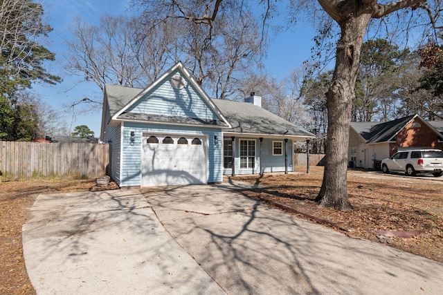 view of front facade with driveway, a chimney, an attached garage, and fence