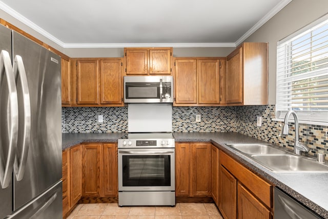 kitchen with stainless steel appliances, ornamental molding, backsplash, and a sink