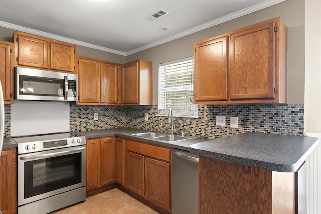 kitchen with crown molding, stainless steel appliances, dark countertops, visible vents, and a sink