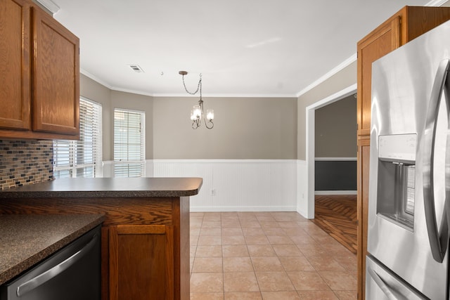 kitchen with crown molding, dark countertops, visible vents, appliances with stainless steel finishes, and wainscoting