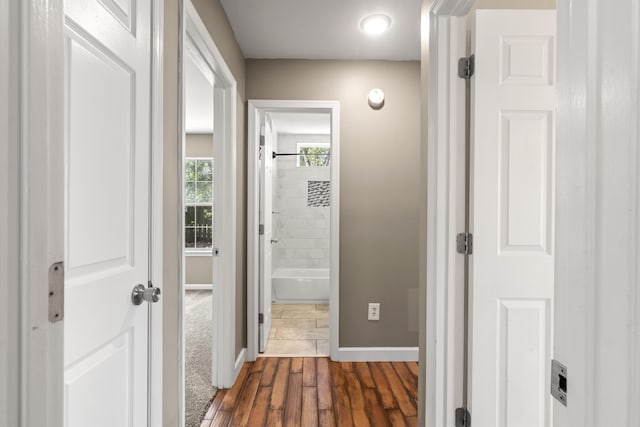 hall featuring baseboards and dark wood-type flooring