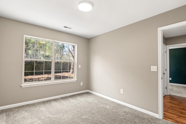 carpeted empty room with visible vents and baseboards