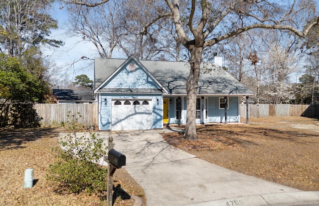 view of front facade with driveway, a garage, a chimney, fence, and a porch