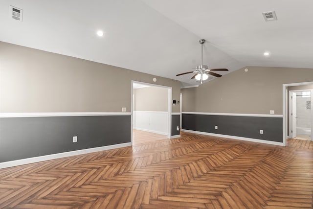 empty room with baseboards, visible vents, vaulted ceiling, and a ceiling fan