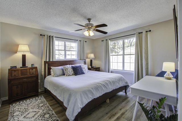 bedroom featuring multiple windows, wood finished floors, and a ceiling fan