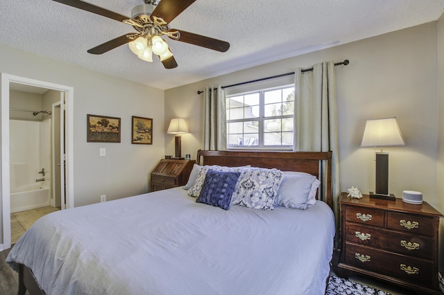 bedroom with tile patterned floors, a ceiling fan, a textured ceiling, and ensuite bathroom