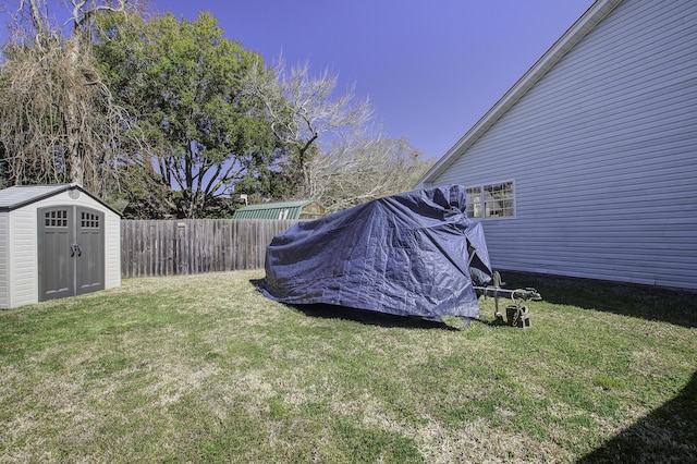 view of yard with a shed, an outdoor structure, and fence