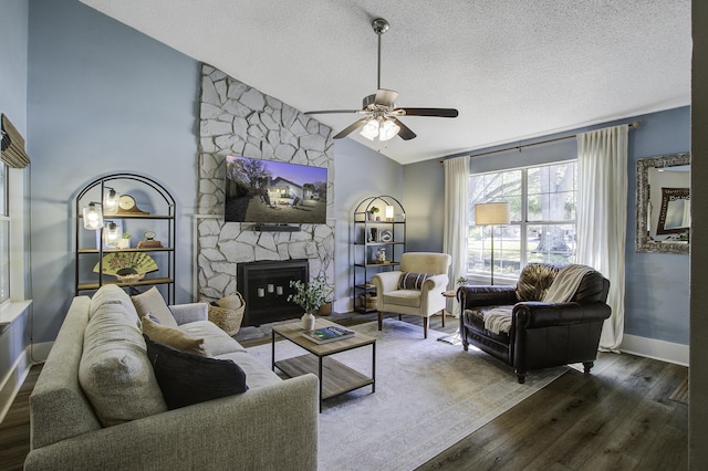 living room featuring a textured ceiling, a fireplace, lofted ceiling, ceiling fan, and dark wood-style flooring