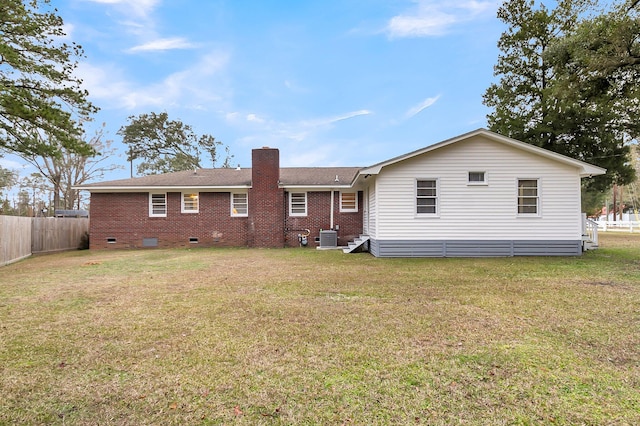 back of property featuring a lawn and central air condition unit