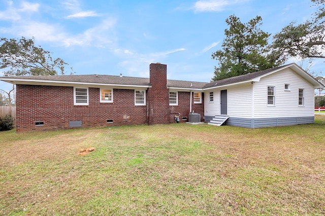 back of property with central AC unit and a lawn