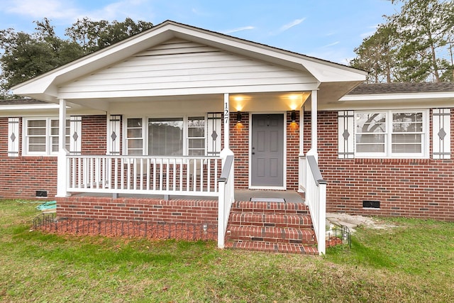 bungalow-style house with covered porch and a front yard