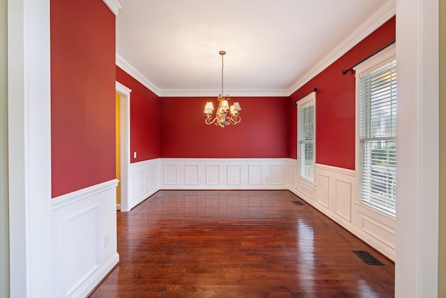 unfurnished dining area with ornamental molding, a healthy amount of sunlight, dark hardwood / wood-style floors, and a notable chandelier