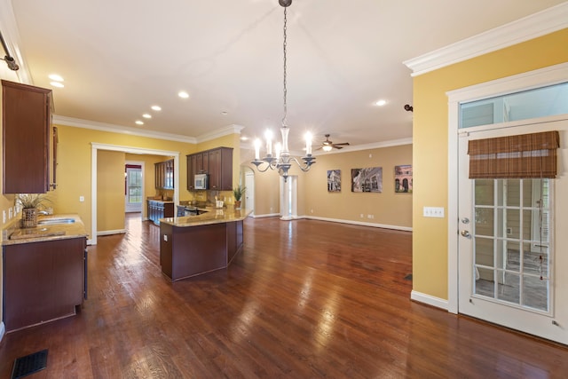 kitchen with ornamental molding, dark hardwood / wood-style flooring, an inviting chandelier, sink, and hanging light fixtures