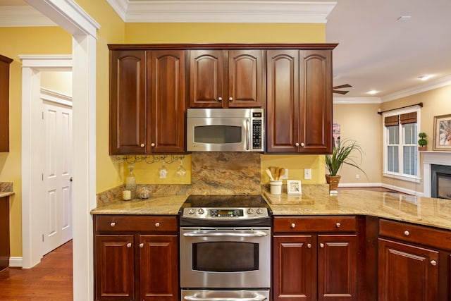 kitchen featuring ornamental molding, stainless steel appliances, light stone countertops, ceiling fan, and dark wood-type flooring