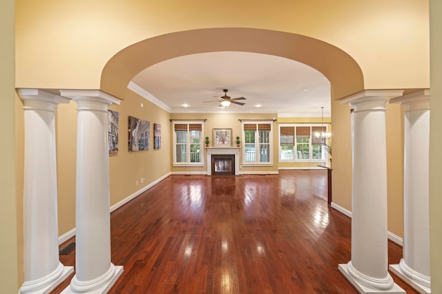 unfurnished living room with ceiling fan with notable chandelier and decorative columns