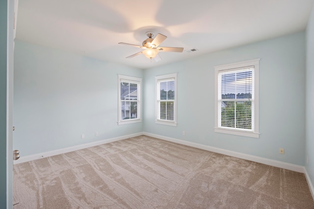 spare room featuring light colored carpet and ceiling fan