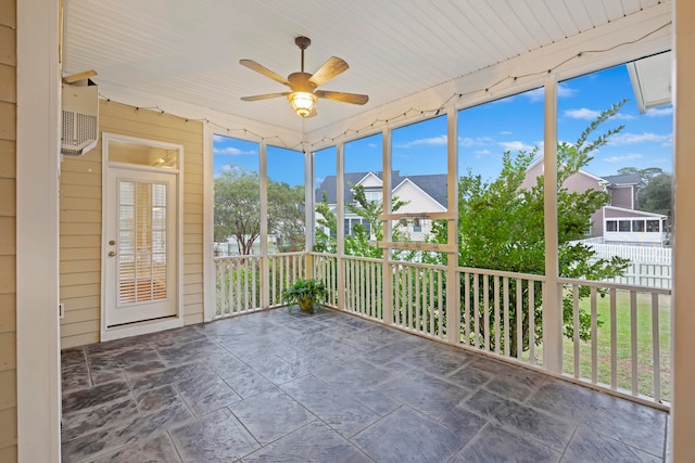 unfurnished sunroom with ceiling fan