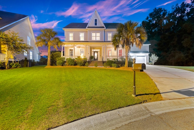 view of front facade with a yard, a porch, and a garage