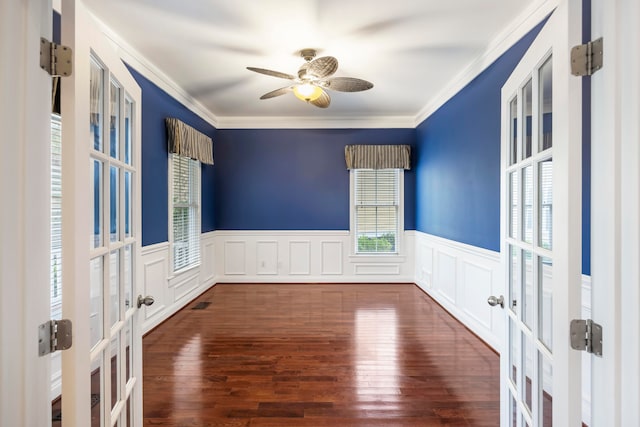 empty room featuring crown molding, dark wood-type flooring, ceiling fan, and french doors