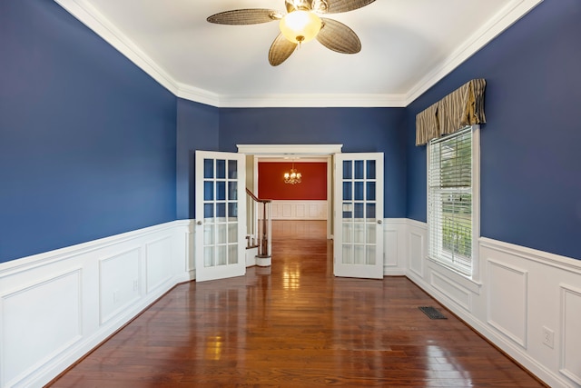 empty room with ceiling fan with notable chandelier, french doors, dark hardwood / wood-style flooring, and ornamental molding