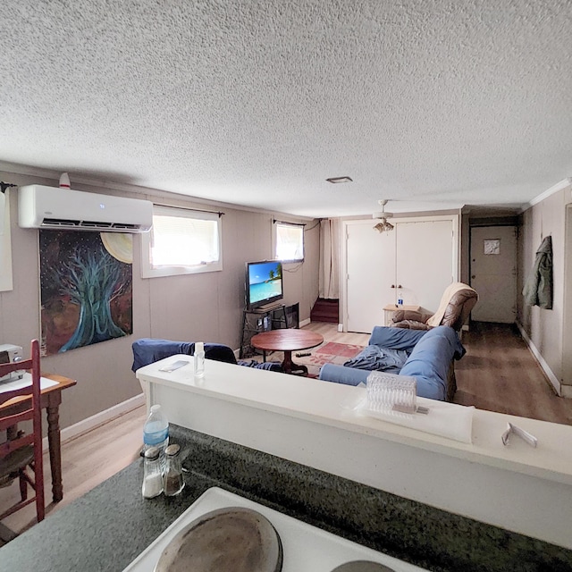 1201 Crescent St, Summerton, SC 29148 - living area with a wall unit AC, a textured ceiling, and light wood-type flooring
