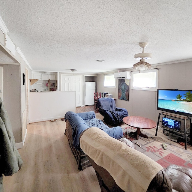 1201 Crescent St, Summerton, SC 29148 - living area with light wood-style floors, a wall unit AC, a textured ceiling, and ceiling fan