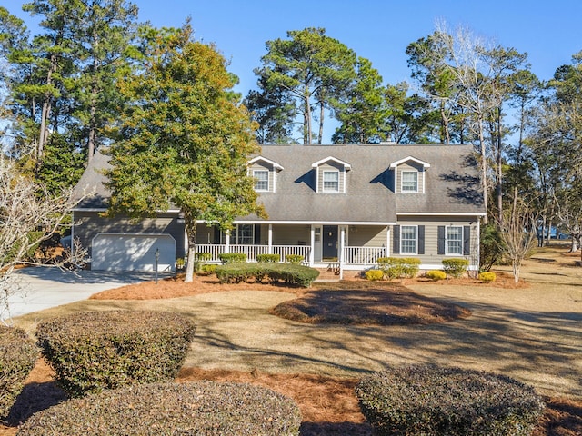 cape cod-style house featuring a garage, covered porch, and concrete driveway