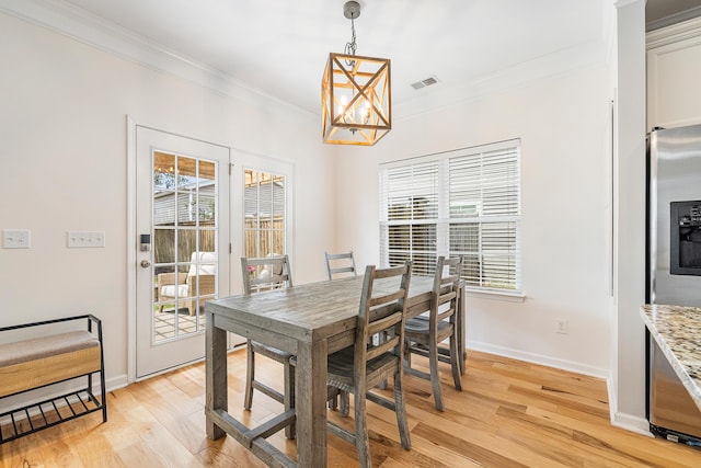 dining area with an inviting chandelier, baseboards, crown molding, and plenty of natural light