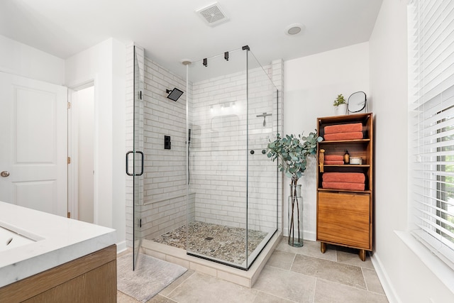 bathroom with visible vents, baseboards, a stall shower, and vanity