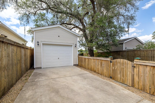 detached garage with fence and concrete driveway