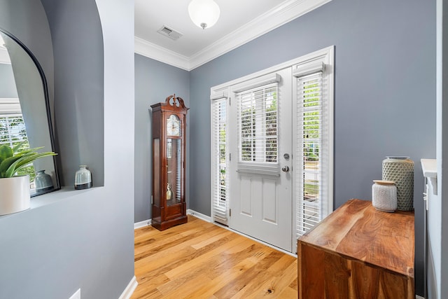 entrance foyer with visible vents, ornamental molding, baseboards, and light wood-type flooring