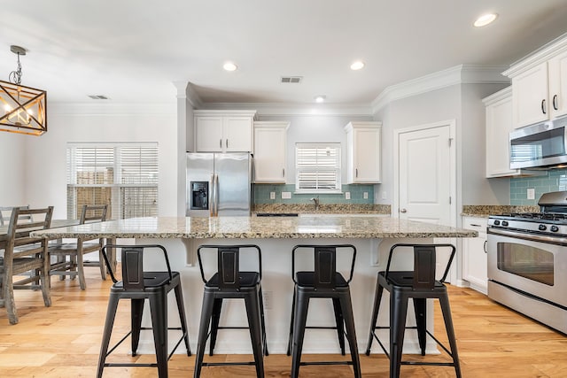 kitchen featuring a breakfast bar area, a notable chandelier, appliances with stainless steel finishes, and a center island