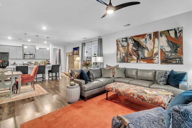 living room with ceiling fan and wood-type flooring