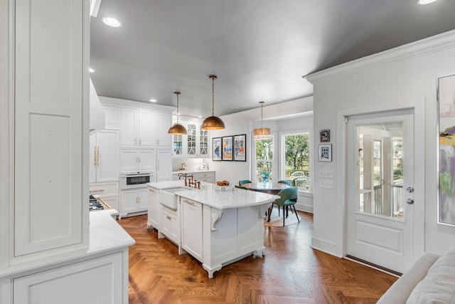 kitchen featuring a sink, light countertops, recessed lighting, and white cabinetry