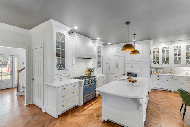 kitchen with recessed lighting, light countertops, white cabinetry, and range with gas cooktop