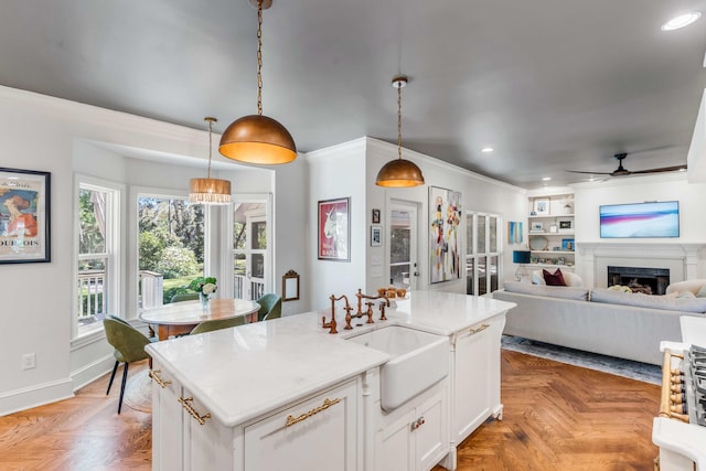 kitchen with ceiling fan, hanging light fixtures, a sink, light countertops, and recessed lighting